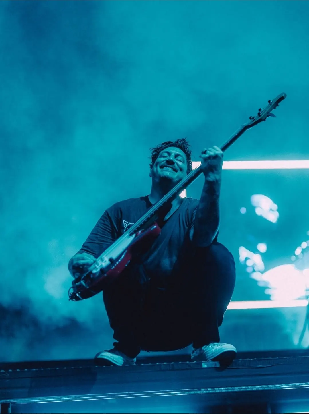 Build a neon-lit musician portrait on stage with a red bass, blue haze, and realistic concert atmosphere.